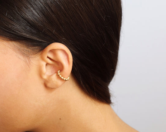 18KT yellow gold earring ear cuff worn by a female ear - Sfere