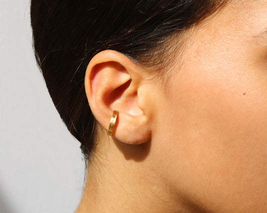 18KT yellow gold earring ear cuff worn by a female ear - Tratti
