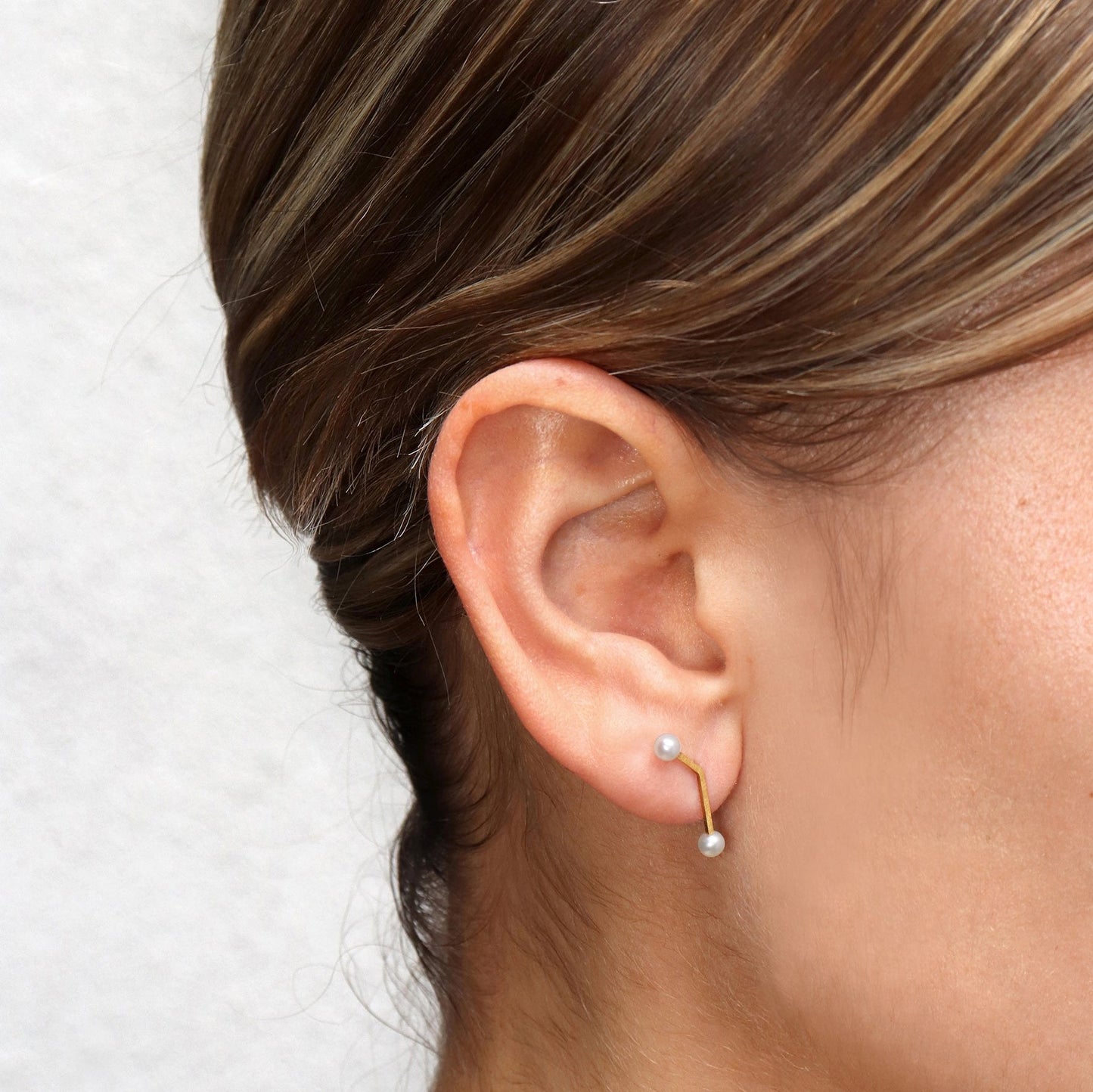 18KT yellow gold earring with freshwater pearls worn by a female ear - Linea PS