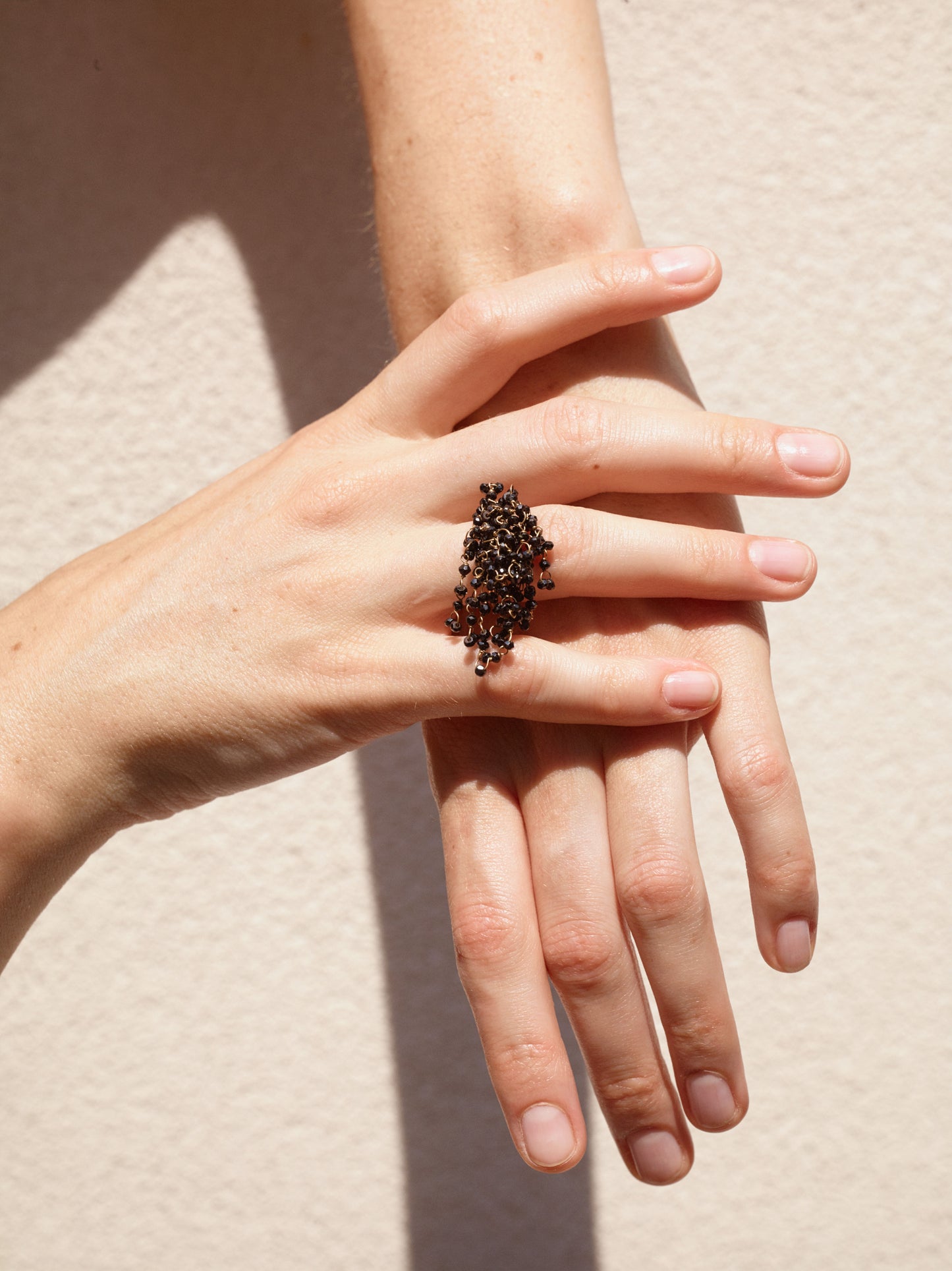 18KT yellow gold ring with black spinels worn by female hand - Victoria