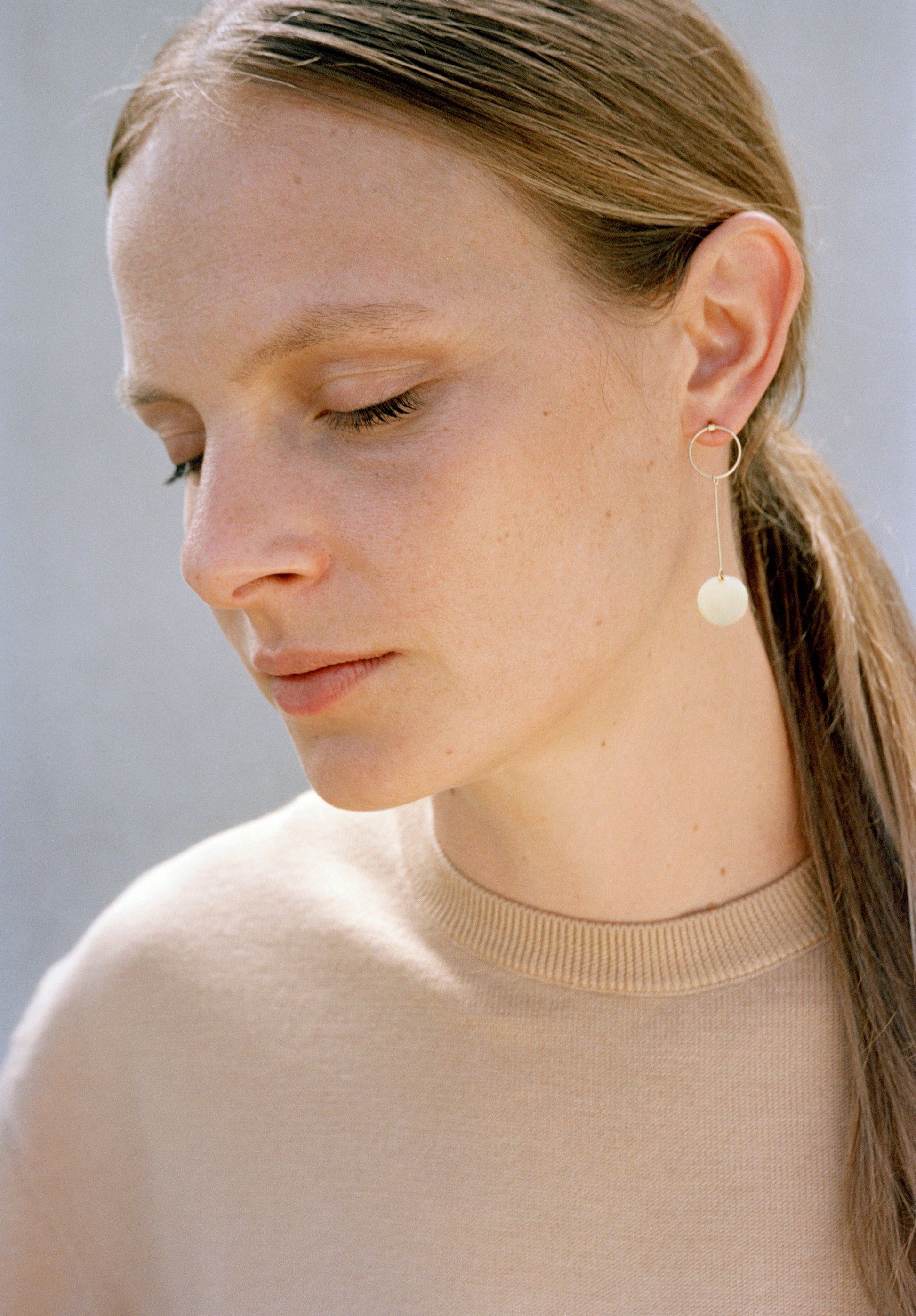 18KT yellow gold hanging earrings worn by a female ear - Pieno Vuoto