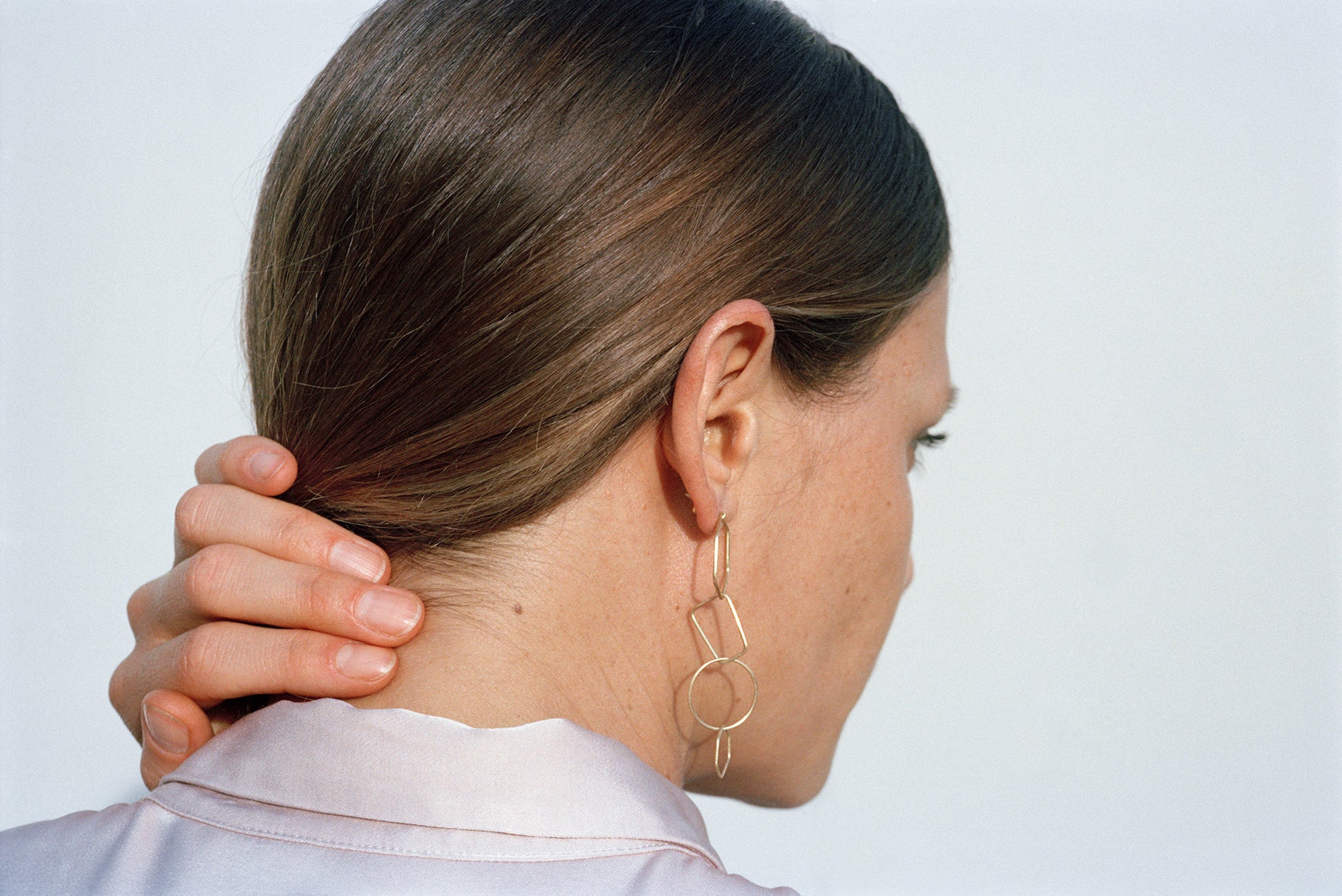 18KT yellow gold hanging earrings with freshwater pearl worn by female ear - Poligoni