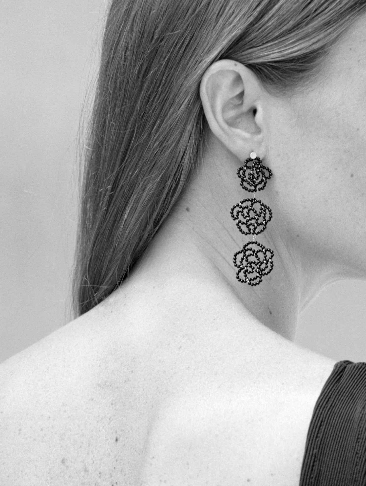 18KT yellow gold pendant earrings and black onyx worn by a female ear - Rosae