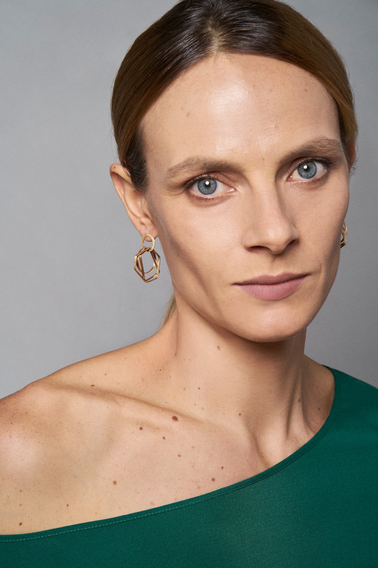 18KT yellow gold hanging earrings worn by a female ear - Sagome