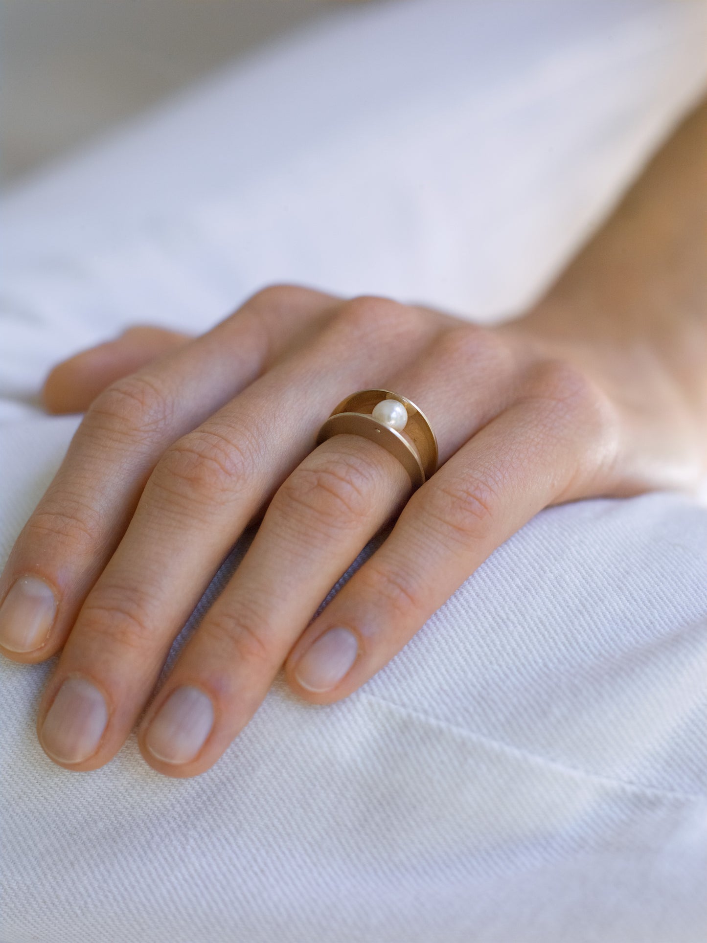 18KT white gold ring with two bands which embrace a gleaming Akoya pearl - Between