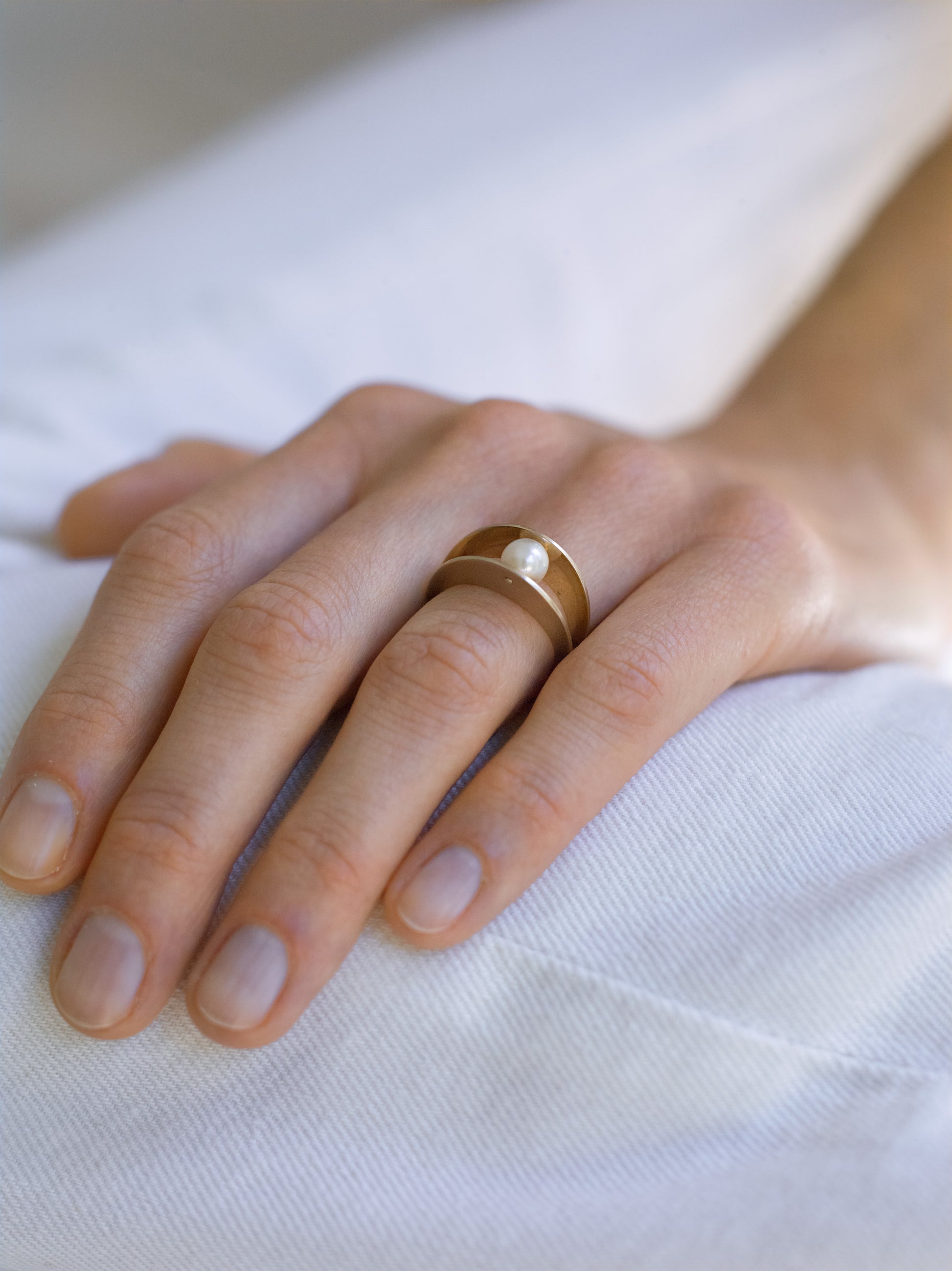 18KT white gold ring with two bands which embrace a gleaming Akoya pearl - Between