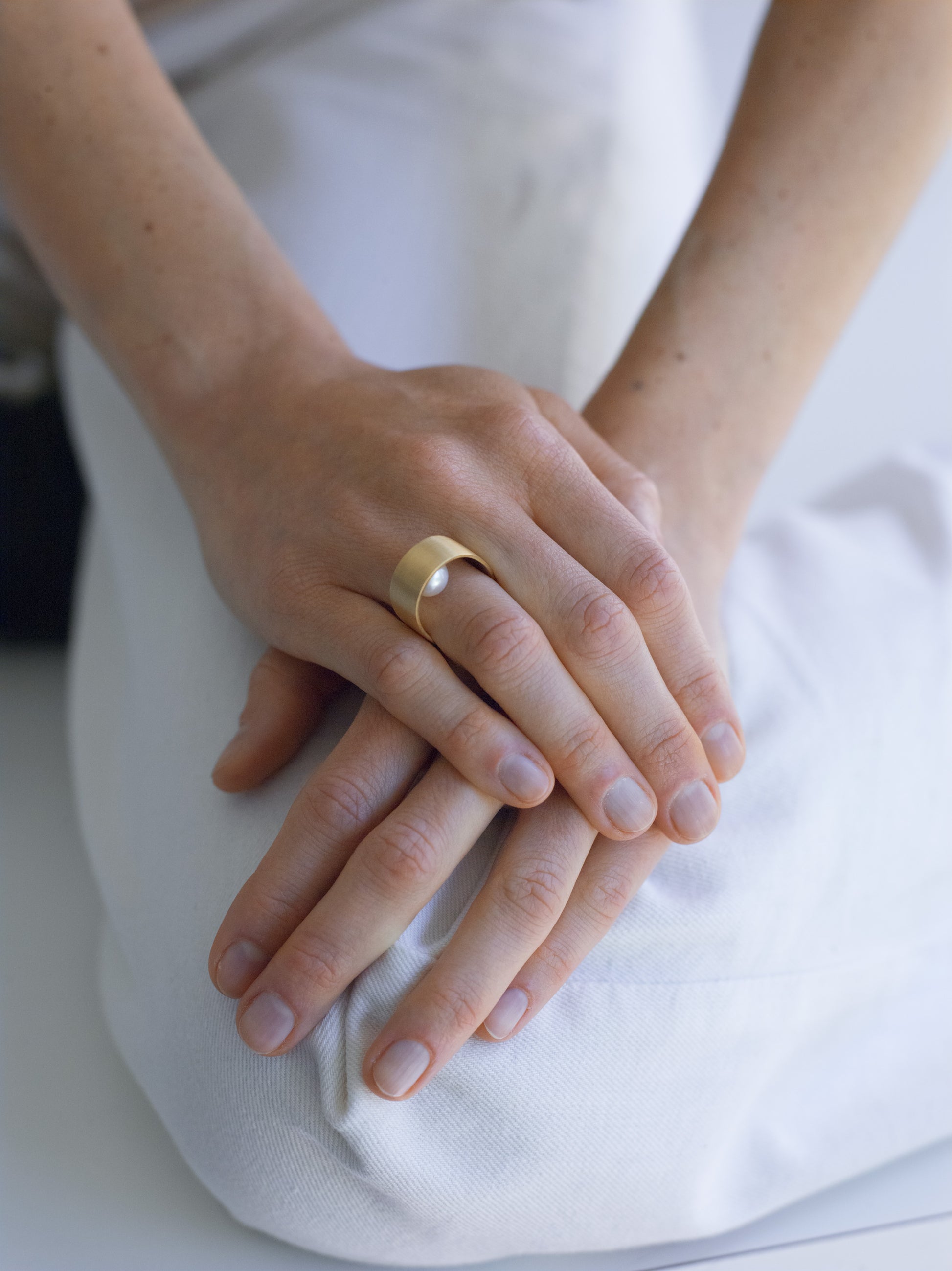 18KT white gold band ring with hidden akoya pearl (diameter 7,3 MM) worn by female hand – Wave