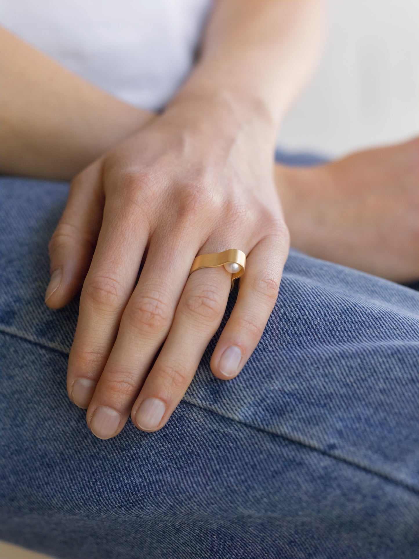 18KT white gold band ring with hidden akoya pearl (diameter 7,3 MM) worn by a female hand – Wave
