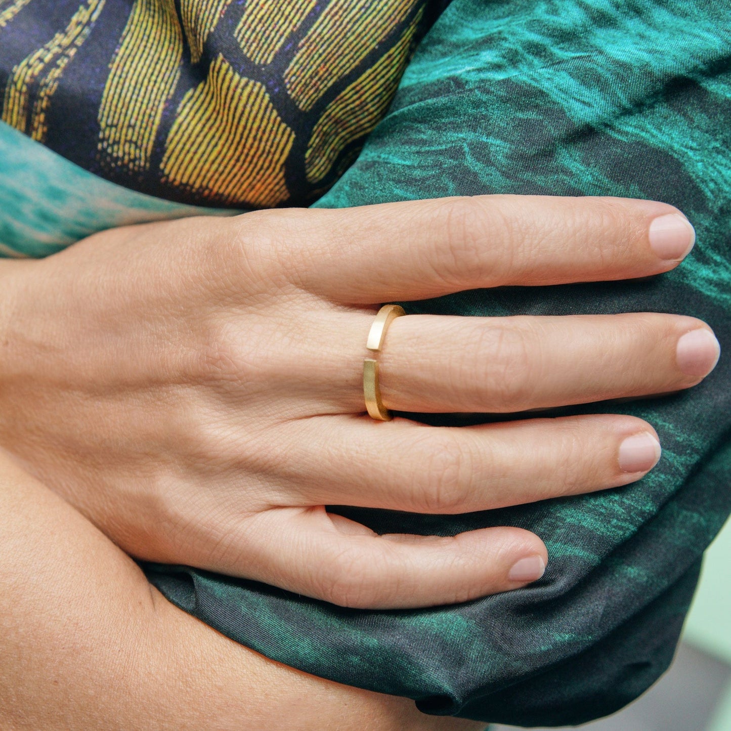 18KT yellow gold wedding ring with diamond worn by a female hand - Squared
