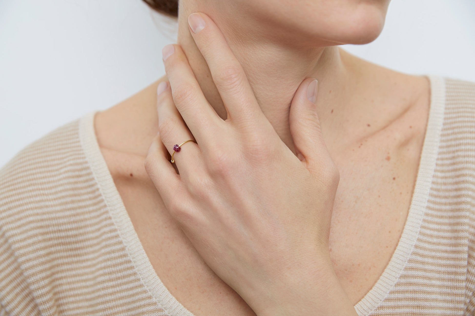 18KT thin yelllow gold ring with ruby worn by a female hand - Toi Rubino