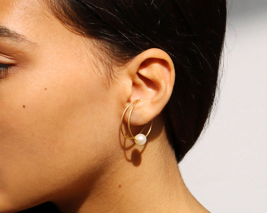 18KT yellow gold earring ear cuff with pearl worn by a female ear - Doppio Cerchio