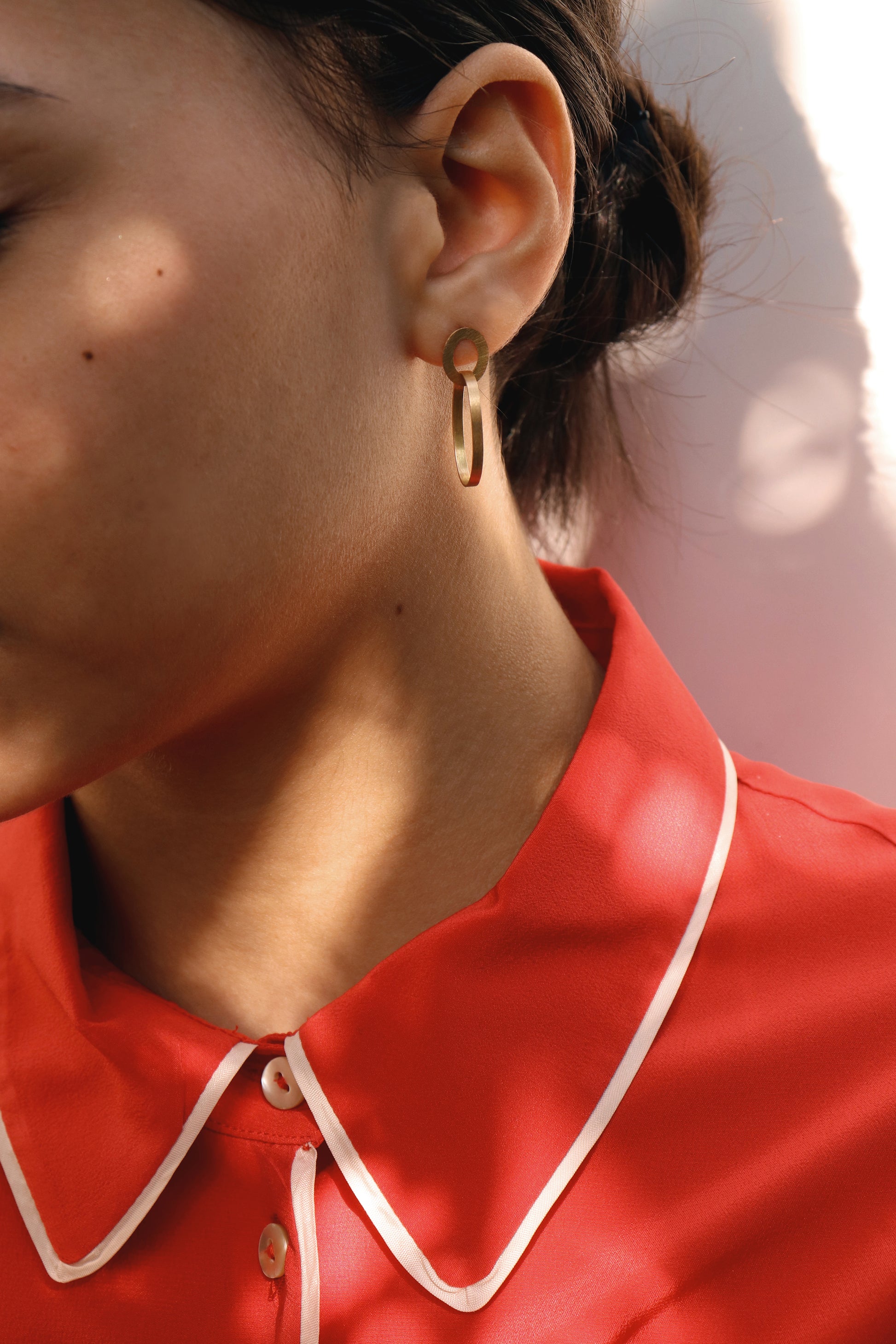 18KT yellow gold hanging earrings worn by a female ear - Insieme 1E