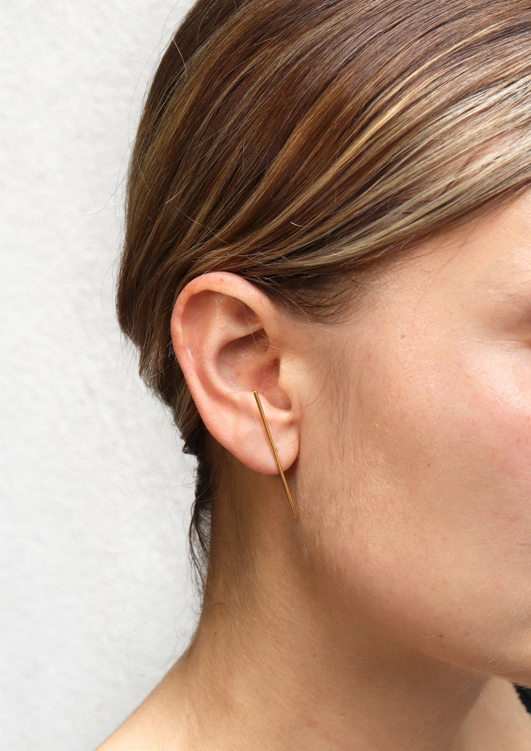 18KT yellow gold earring worn by a female ear - Linea 1E
