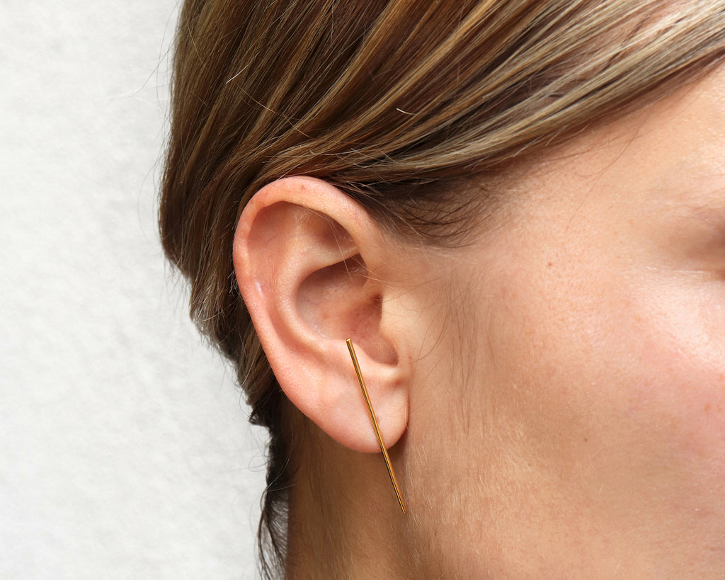 18KT yellow gold earring worn by a female ear - Linea 1E