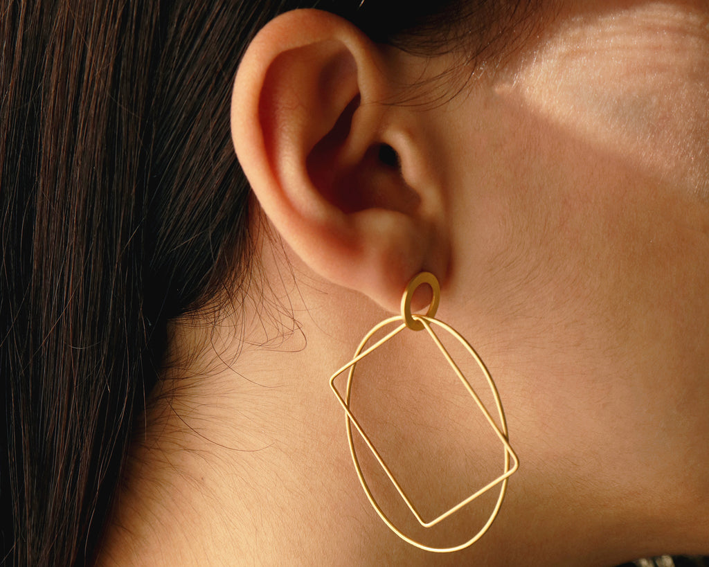 18KT yellow gold hanging earrings worn by a female ear - Ovale Rettangolo E