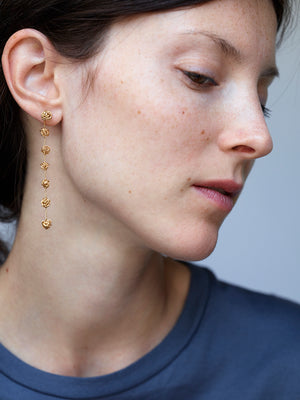 18KT yellow gold long earrings worn by a female ear - Sette Gomitoli
