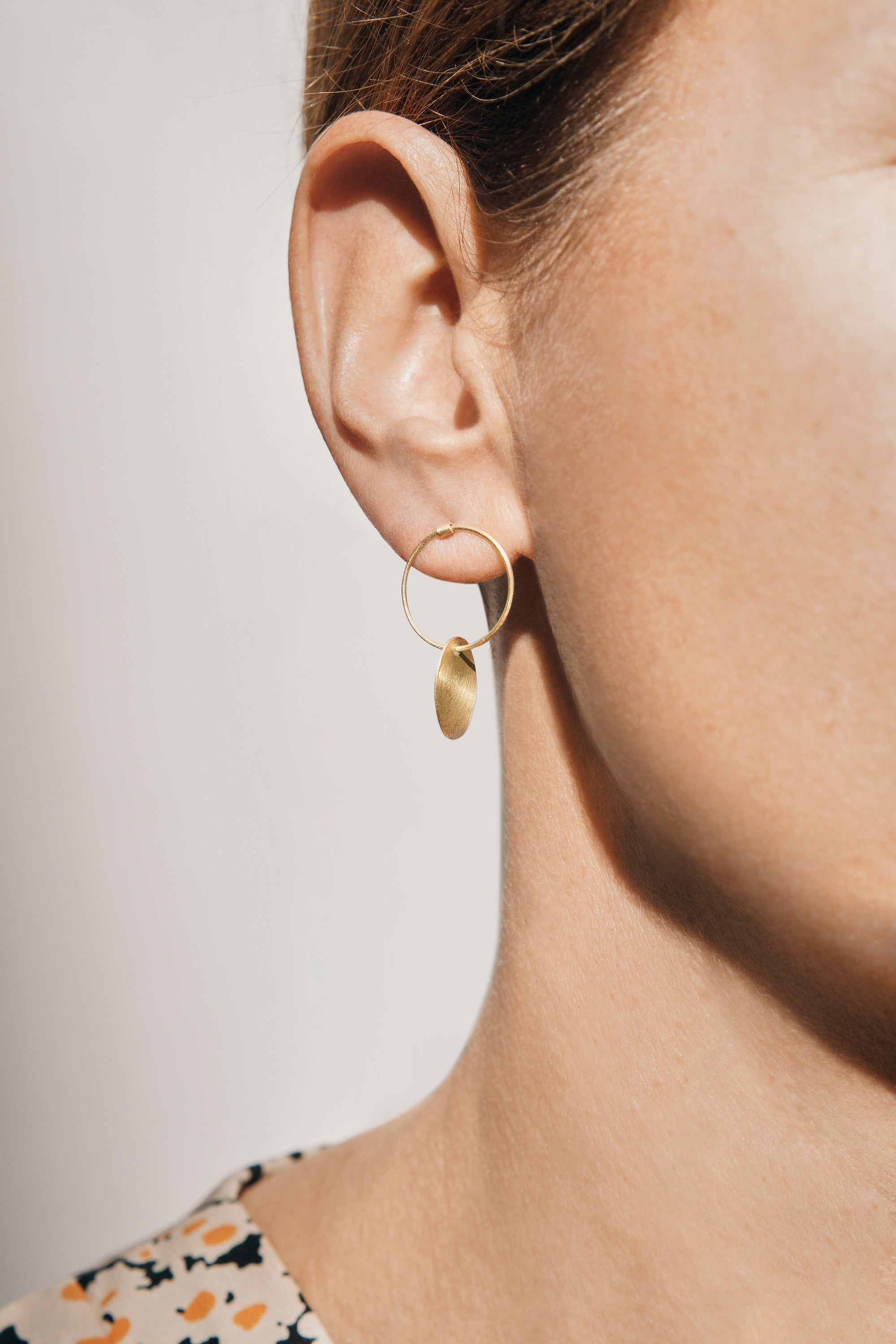 18KT yellow gold hanging earrings worn by a female ear - Pieno Vuoto 4E
