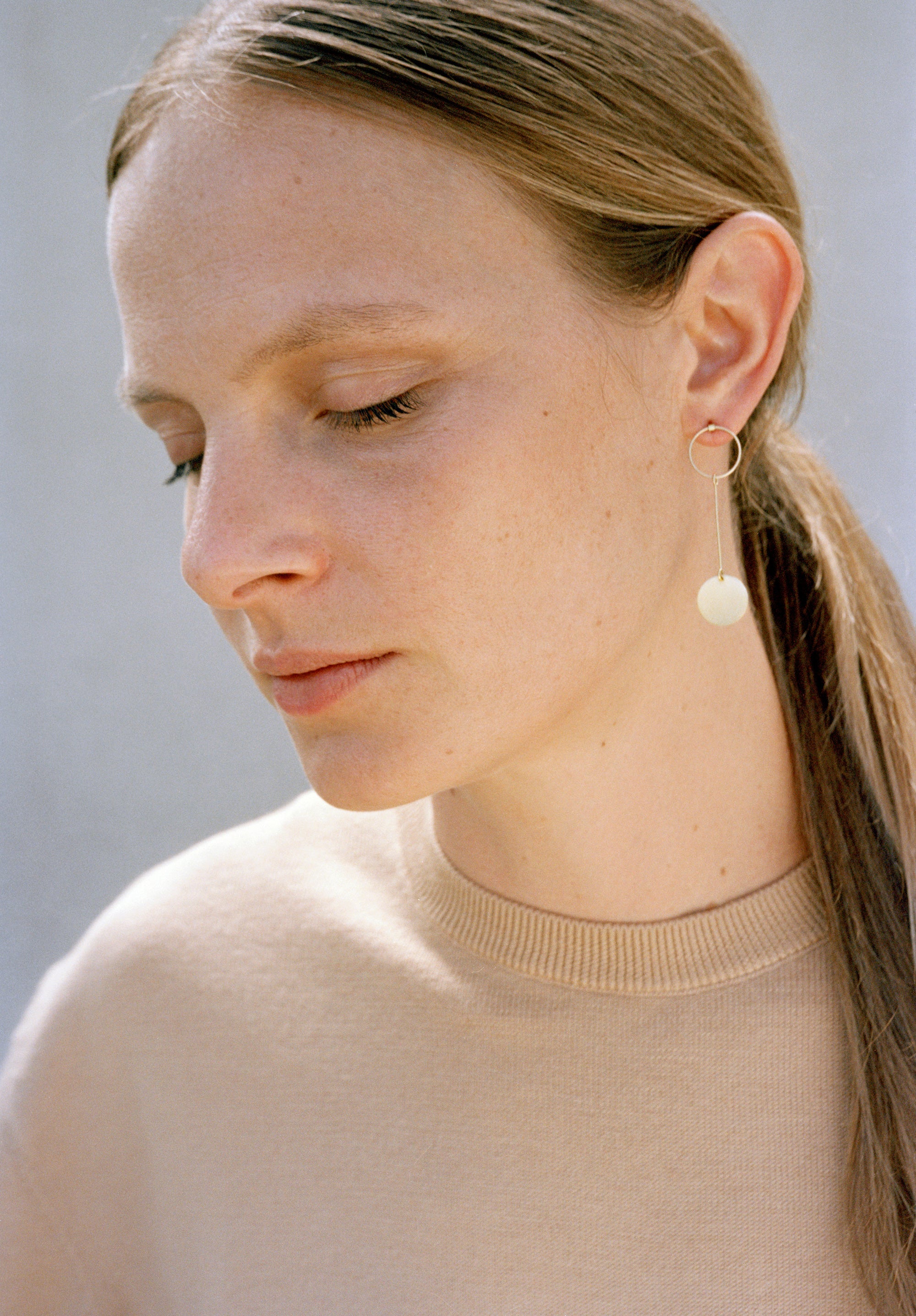 18KT yellow gold hanging earrings worn by a female ear - Pieno Vuoto