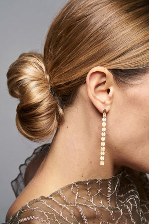 18KT yellow gold pendant earrings worn by a female ear - Progressione 12