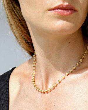 18KT yellow gold short necklace with freshwater pearls worn by female neck – Gomitolini