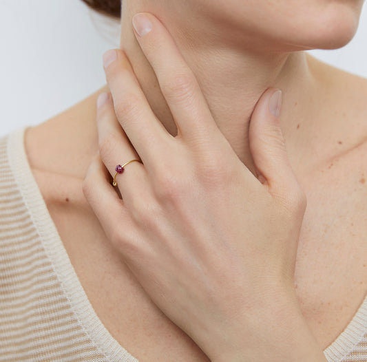 18KT thin yelllow gold ring with ruby worn by a female hand - Toi Rubino